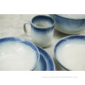 Reactive glazed stoneware dinner set with blue rim